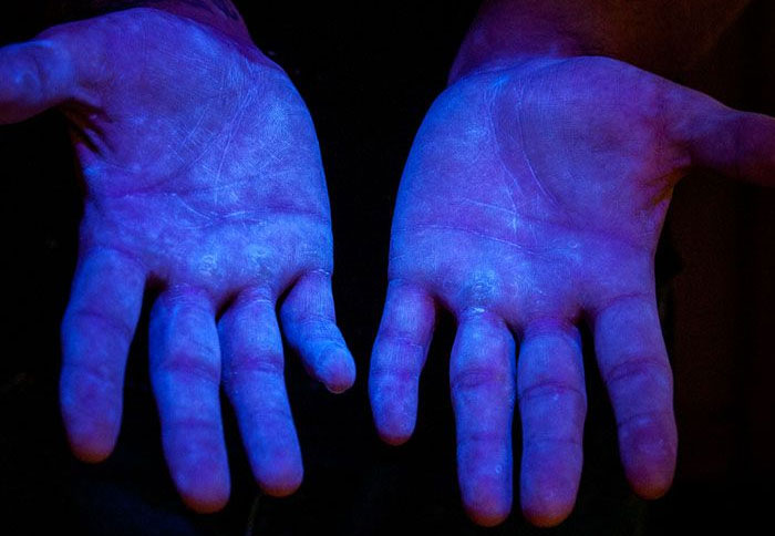 Рисунок 6. Флуоресцентный материал под ультрафиолетовым светом, чтобы увидеть покрытие на руках. Источник: www.glogerm.com
